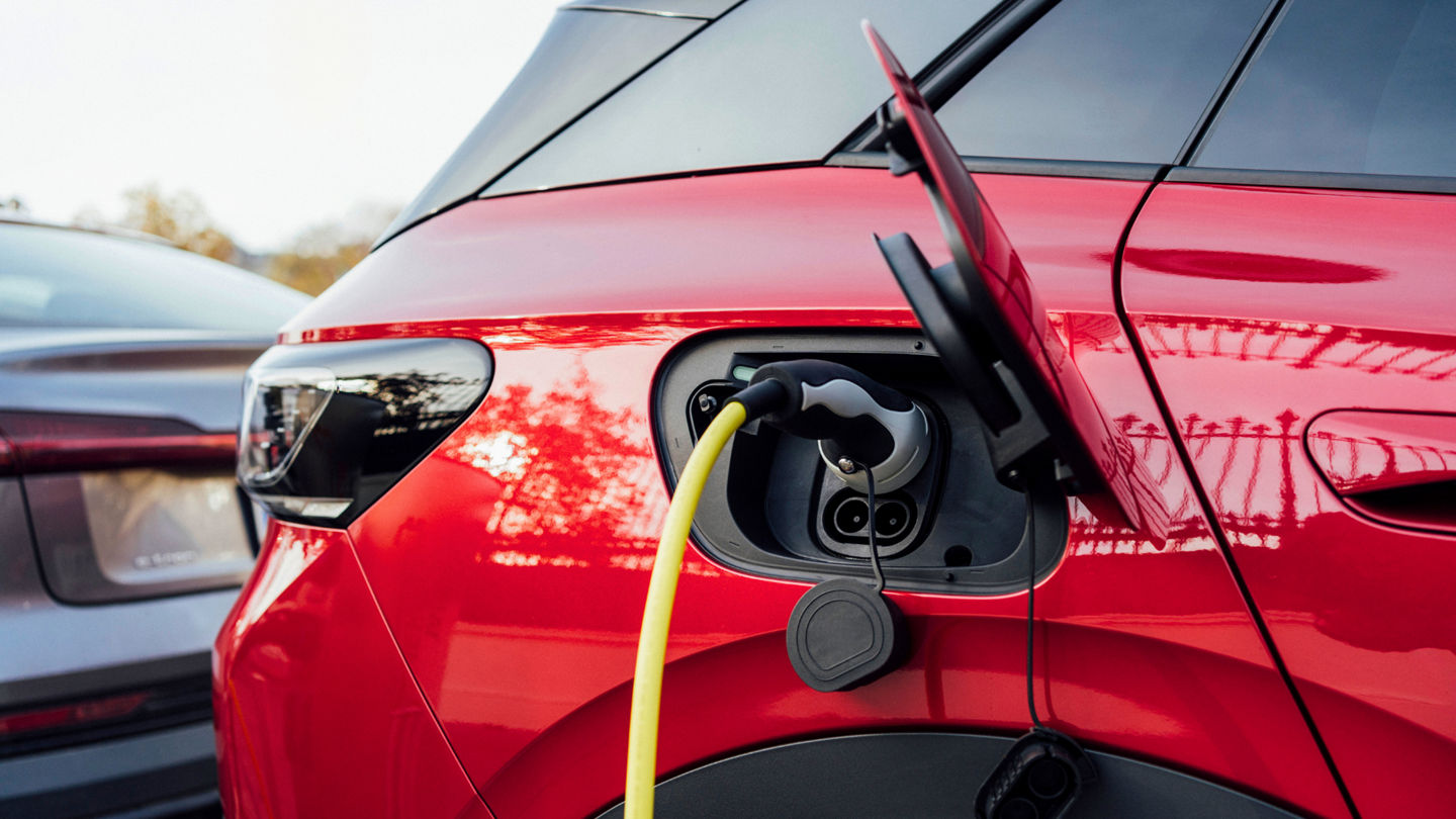 Red electric car being charged