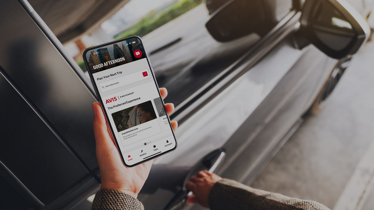 Mockup image of a woman holding and using mobile phone with blank screen while opening the car door