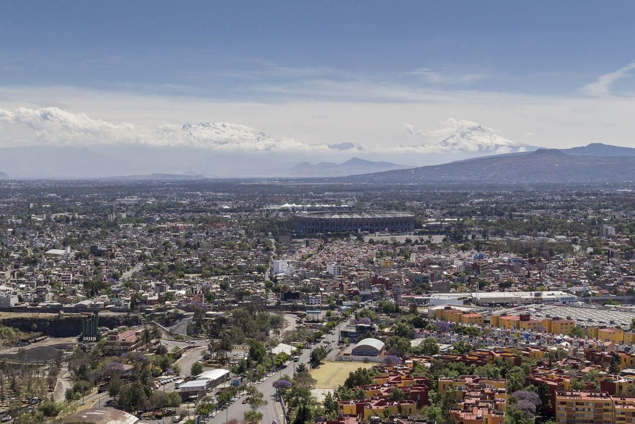 Aerial view of Coapa in Mexico City, with aztec soccer stadium and snowed volcanoes in the back